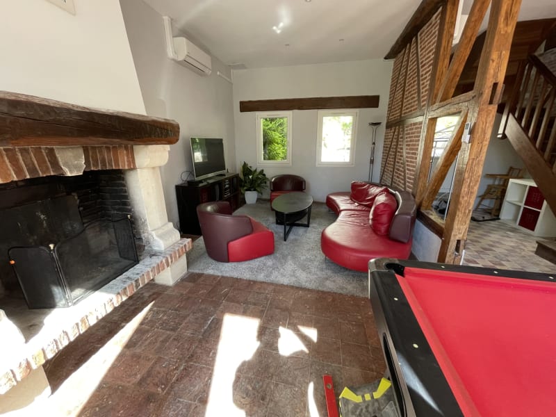 La salle de jeux de la villa Gustave avec billard, fauteuils rouges, cheminée et vue sur le jardin aux Gîtes de Flaubert