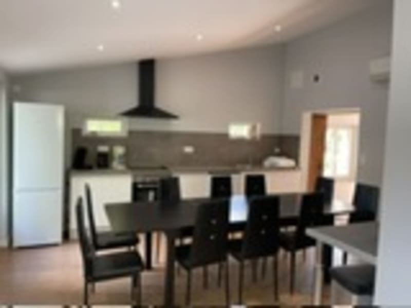 Cuisine et salle à manger modernes aux Gites De Flaubert avec chaises noires et électroménagers en inox