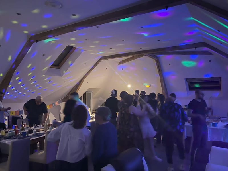 Des invités célèbrent aux Gites De Flaubert avec des lumières de plafond bleu et vert à Le Heron, France