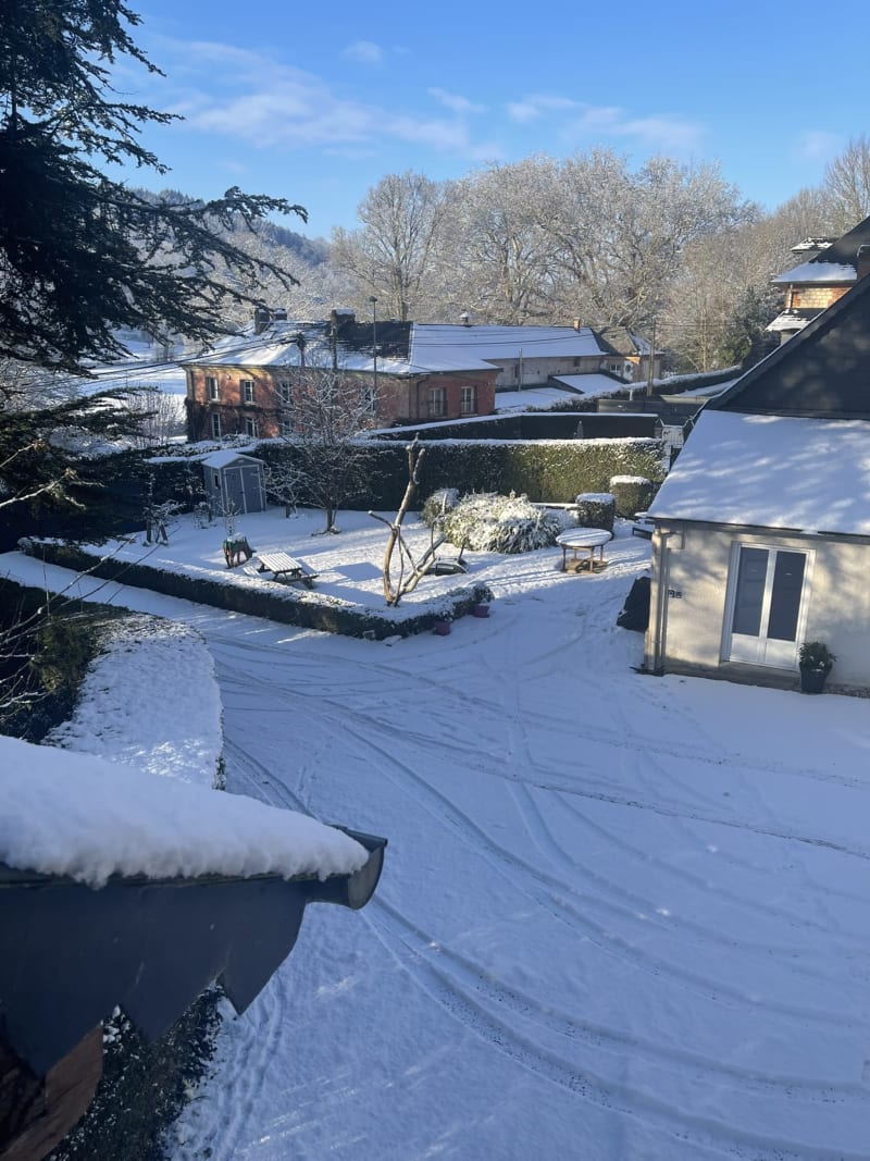 Jardin d'hiver enneigé à la villa Les Gites De Flaubert au Héron, France avec sapins et haies givrées