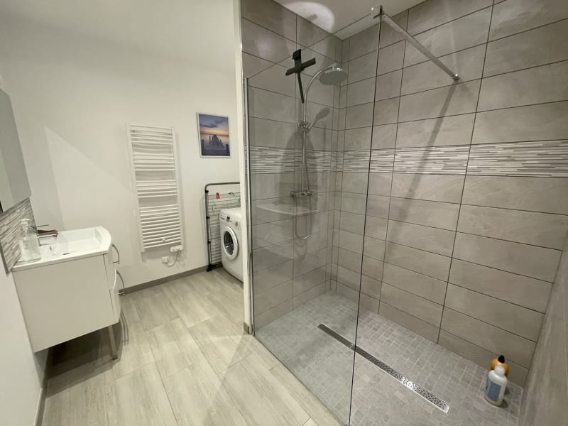 Salle de bain moderne avec douche à l'italienne, lavabo et lave-linge à la villa Les Gîtes De Flaubert au Héron, France