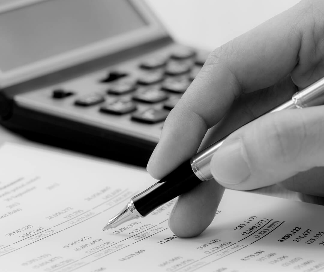 A person holding a pen and a calculator