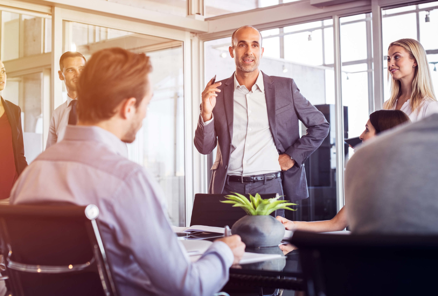 Image of people in an office room discussing business.