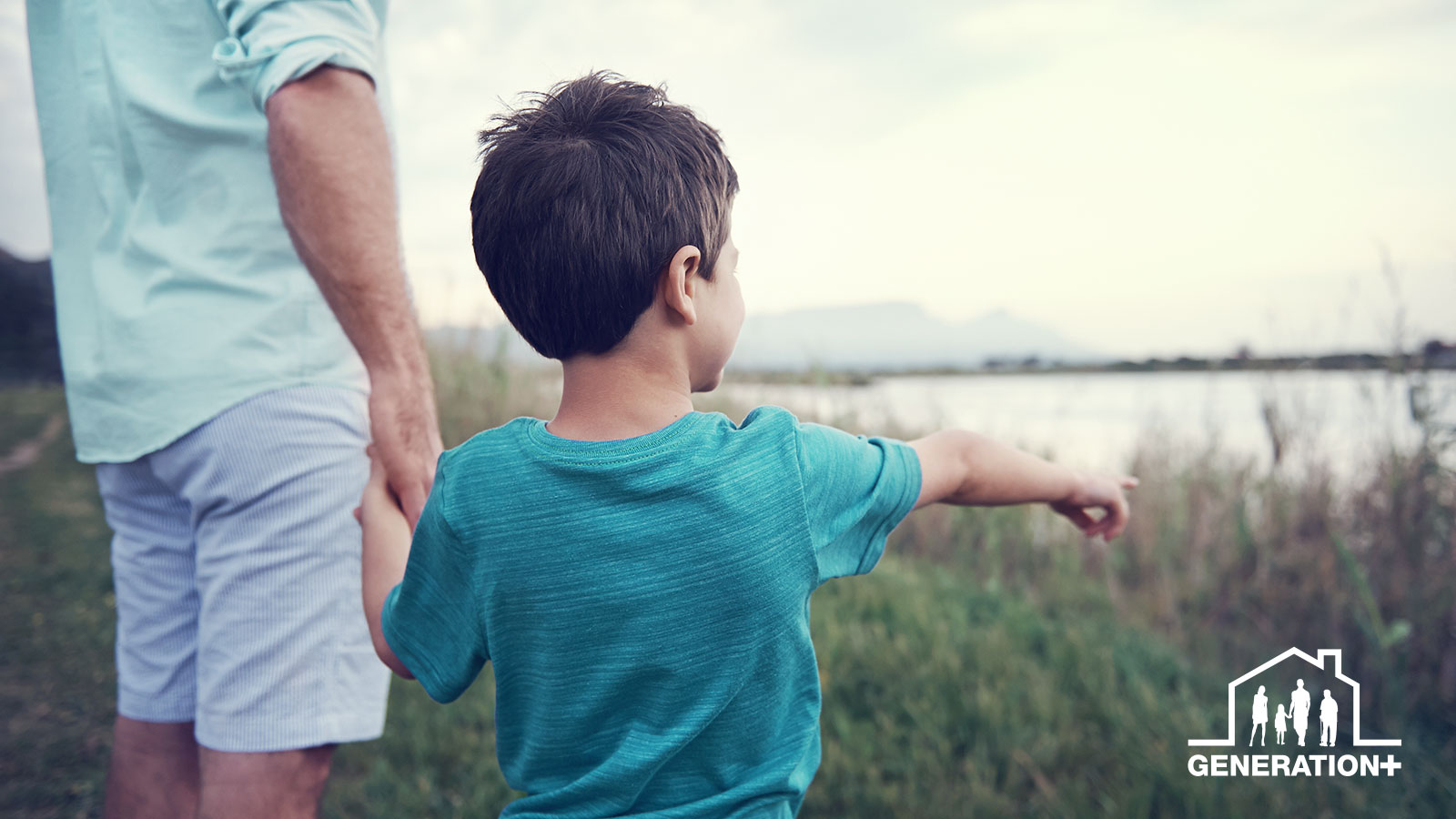 A person with a child near a lake.