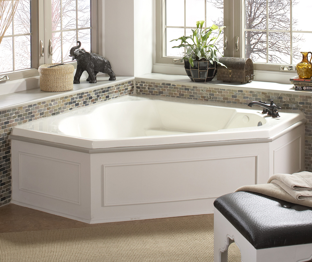 Image of a corner bathtub completed with a small square tile finish with home decor surrounding it on the window seal.