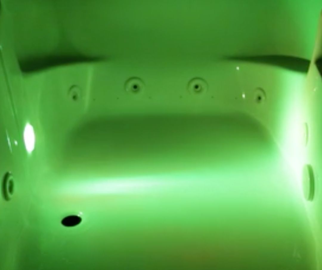 Image of a jetted bath tub with green chrome therapy.