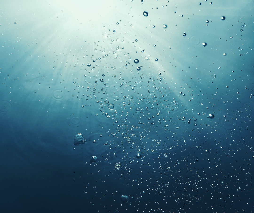 Image of a body of water underwater looking up.