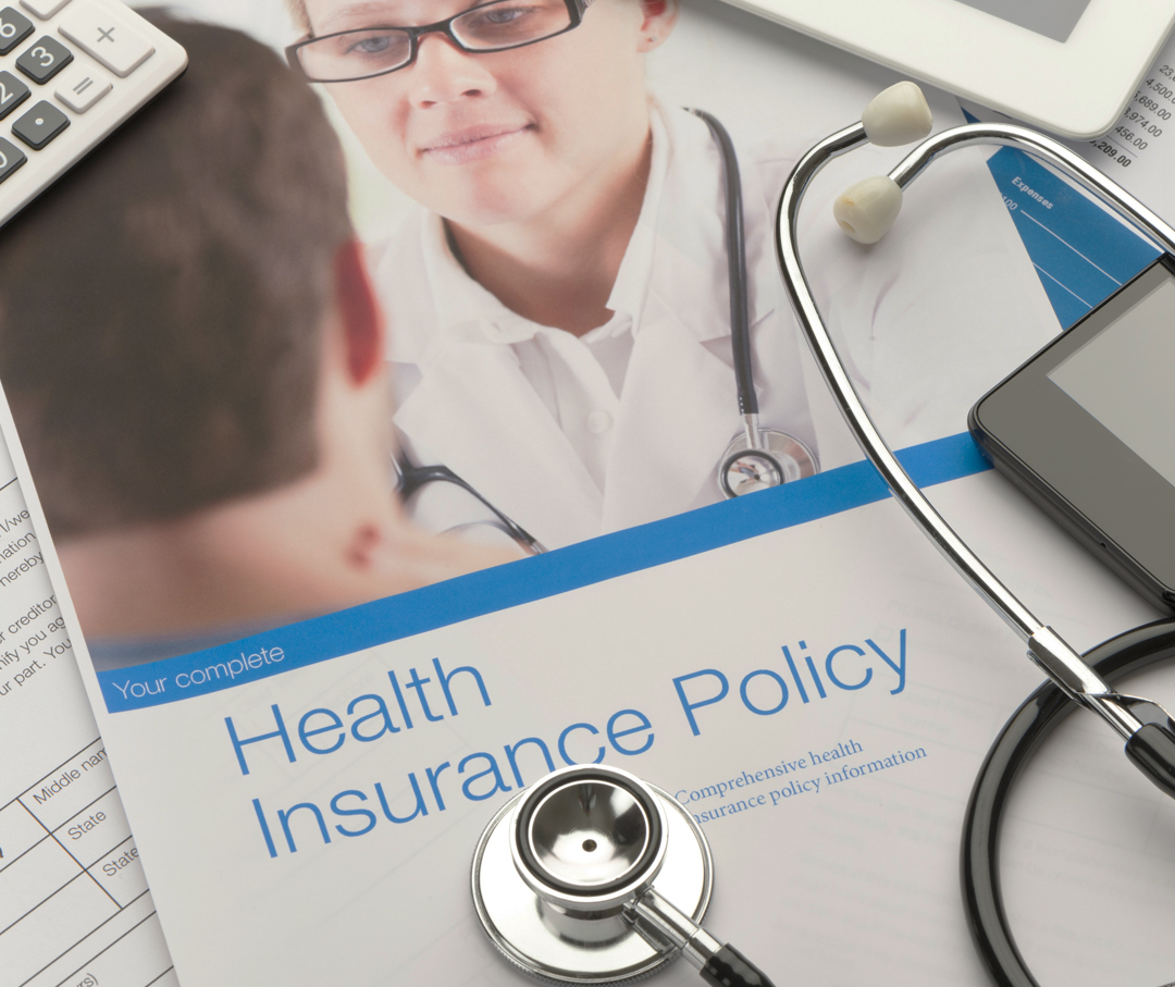 Image of a health insurance policy and a stethoscope.