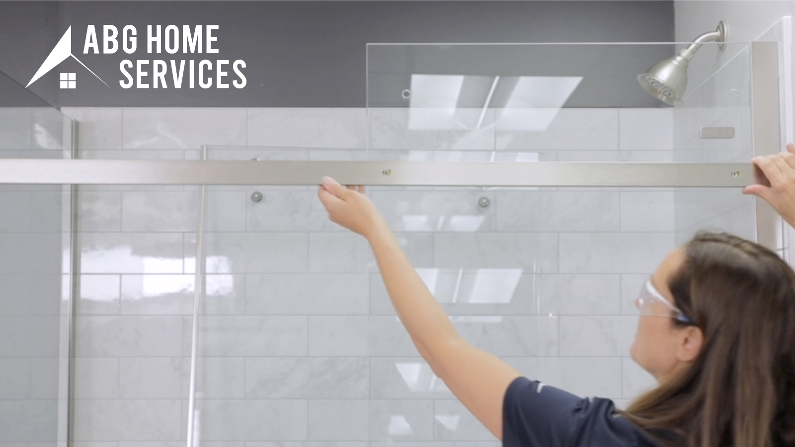 A women installing a glass shower door.