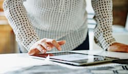 A woman tapping on her iPad.