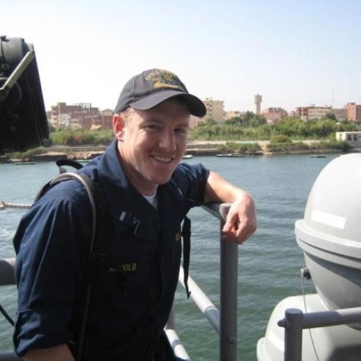 Photograph of person on the back of a boat smiling at camera