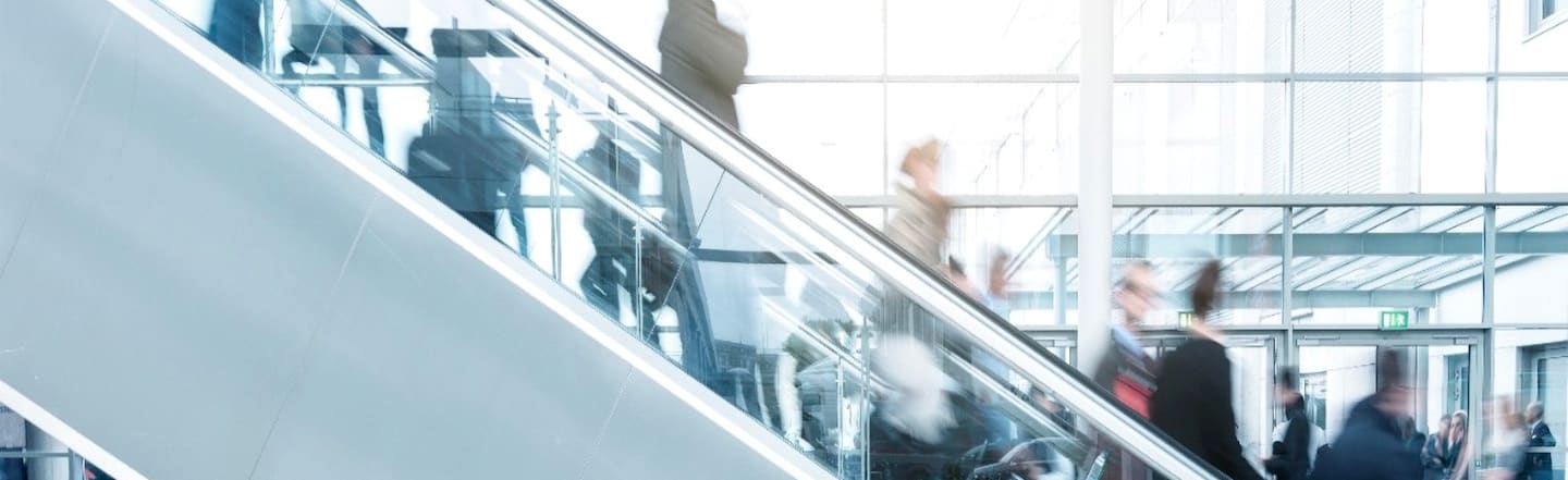 Stylized image of people riding escalators.