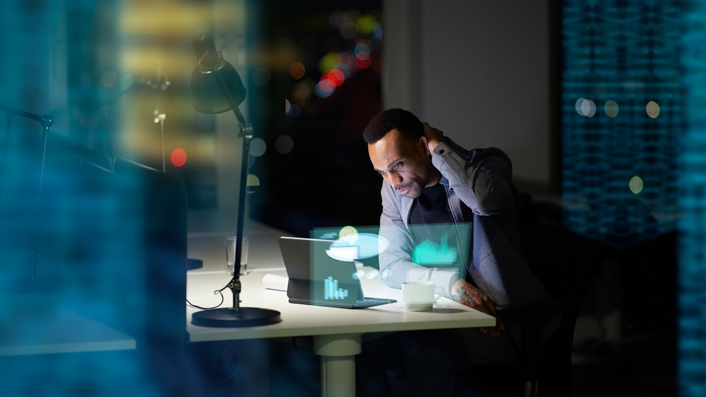 Person looking at laptop at night.