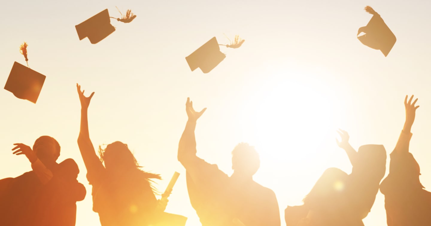 Graduates throwing caps up in the air.