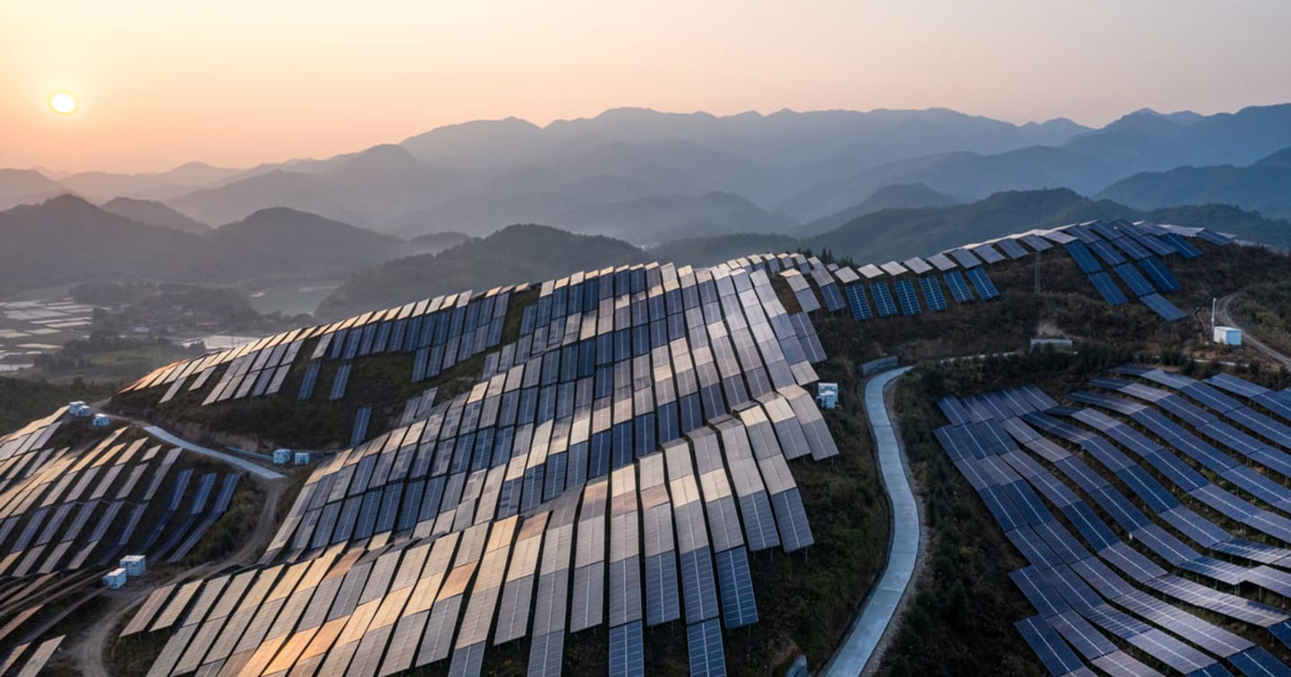 Solar panels lining a hill.