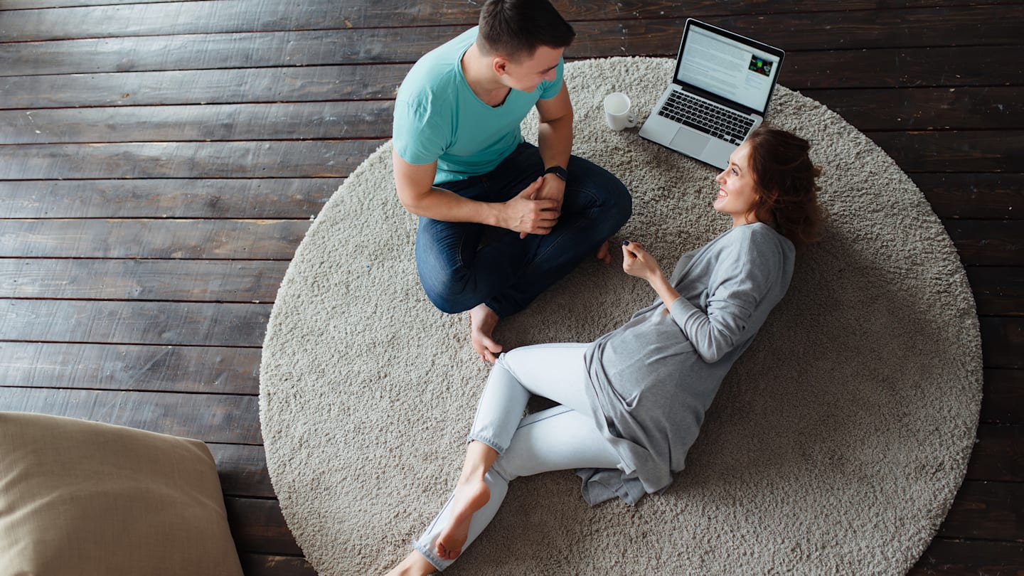 Couple having discussion on living room floor with