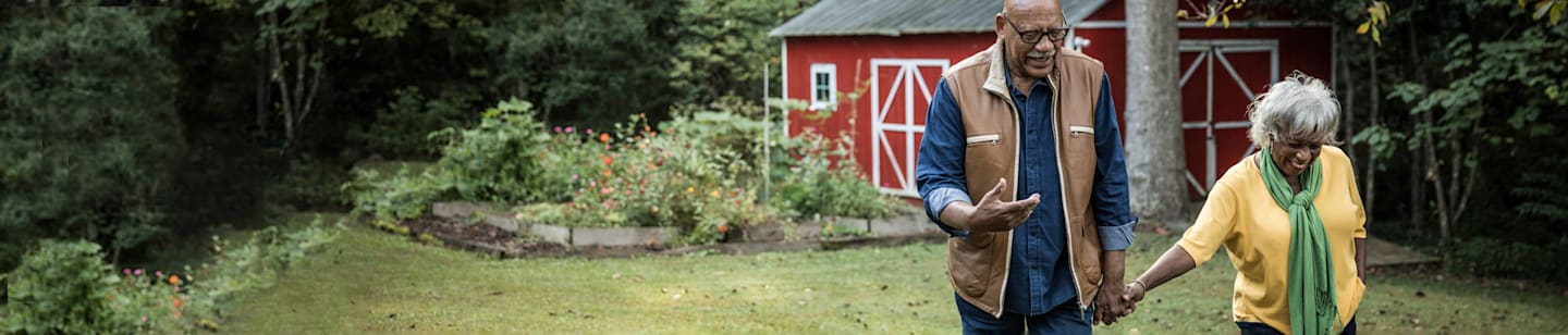 An older man outside near his garden.