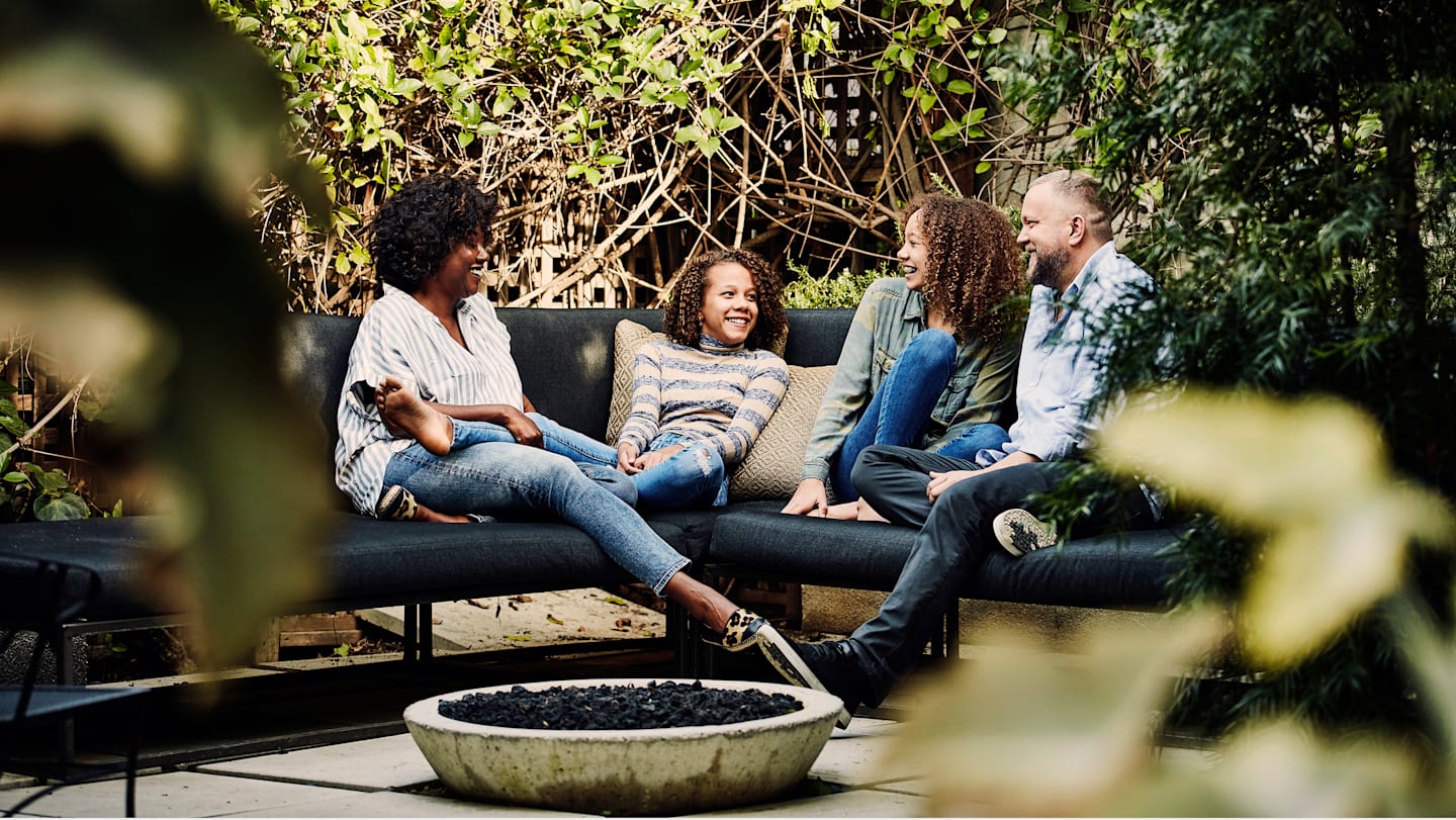 A family sitting on their back yard deck.