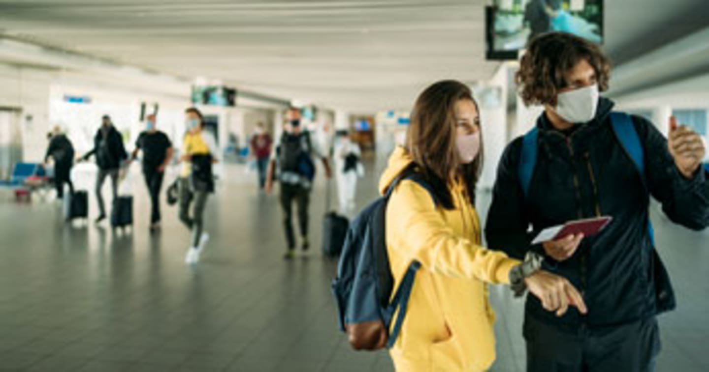 A couple at the airport looking at flight information.