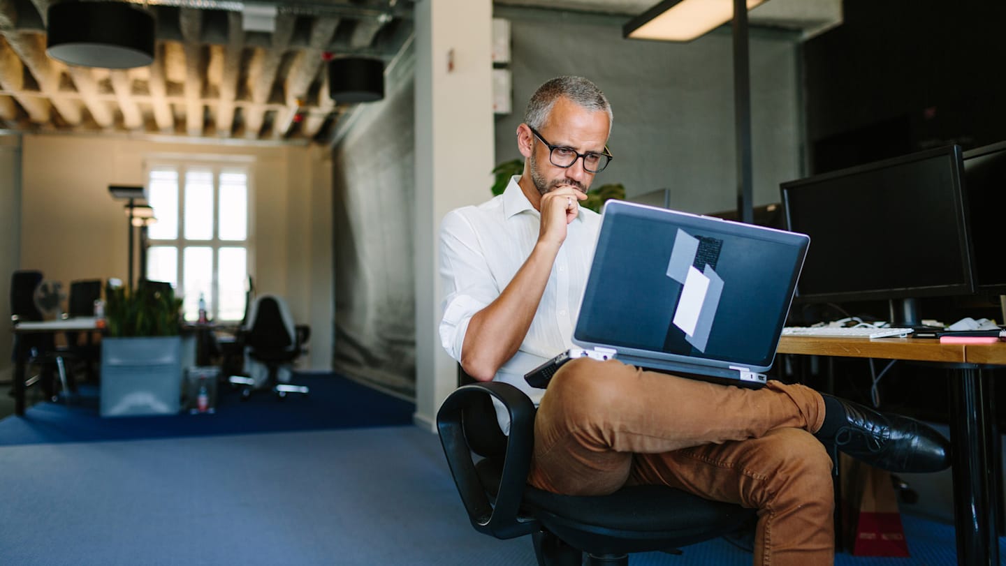 An older man looking at his laptop.
