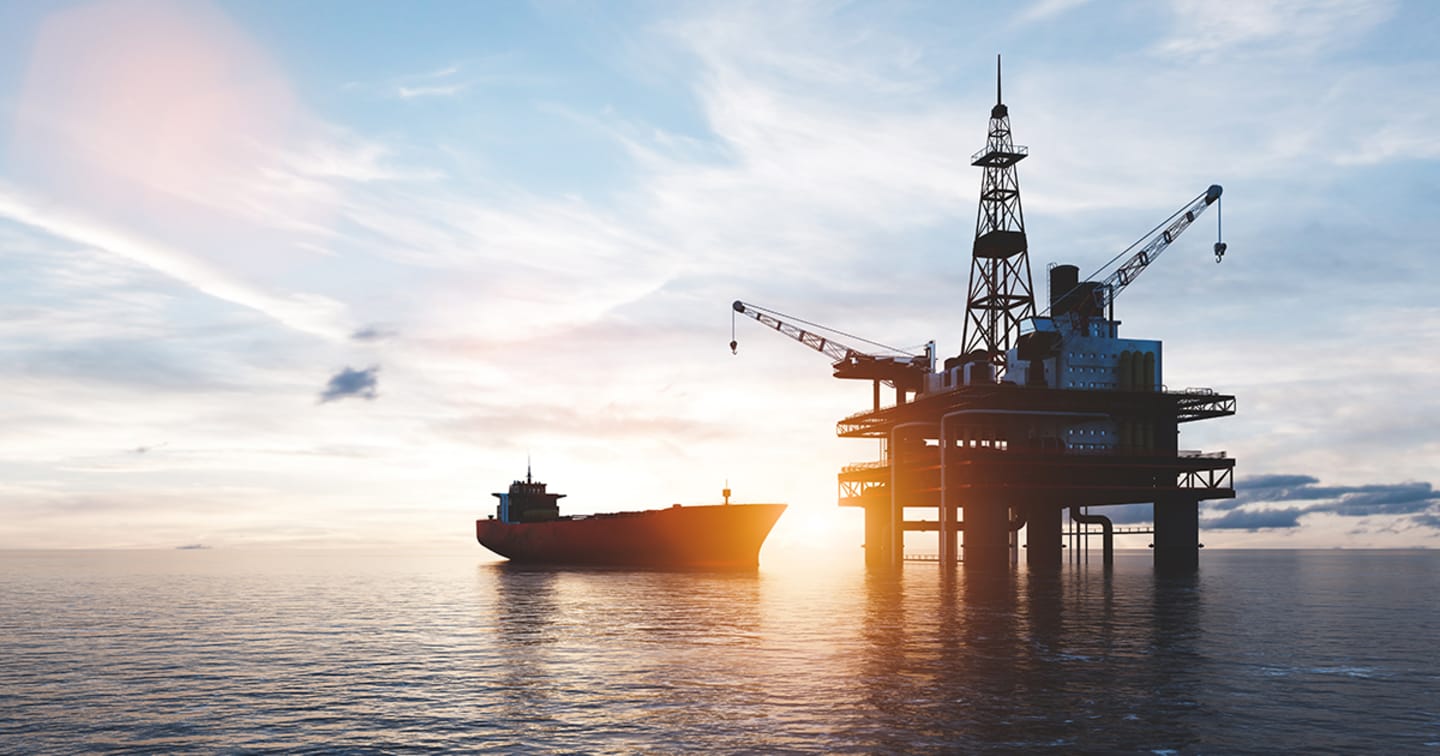 Oil rig and tanker in ocean.