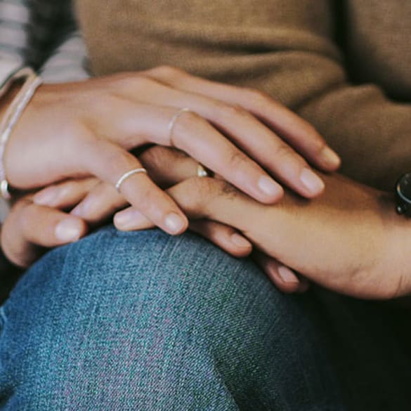 Close-up of married man and woman holding hands.