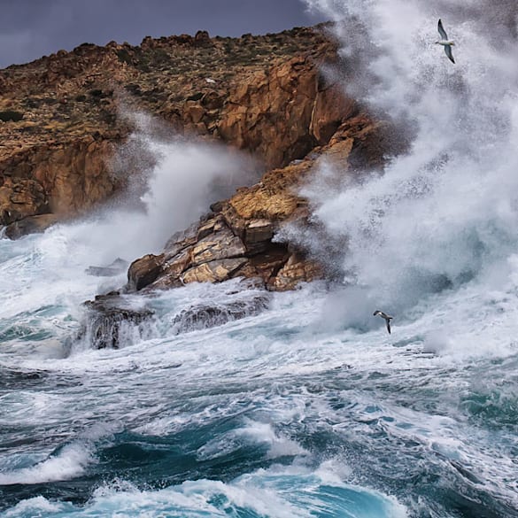Wave breaking over rocks.