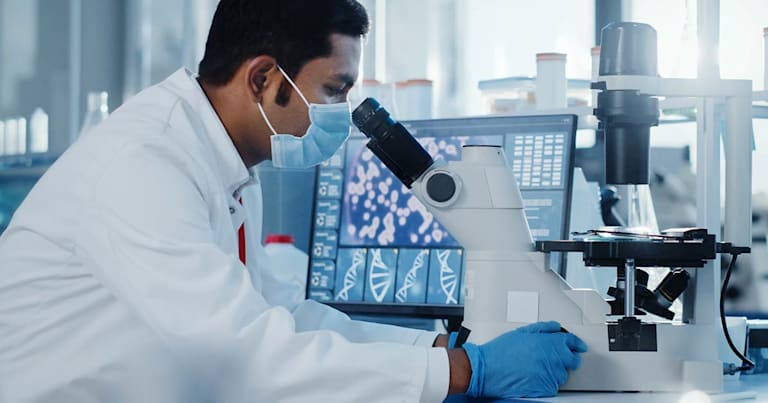 Scientist looking through a mircoscope.