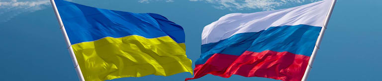 The Ukrainian and Russian flags against a blue sky.