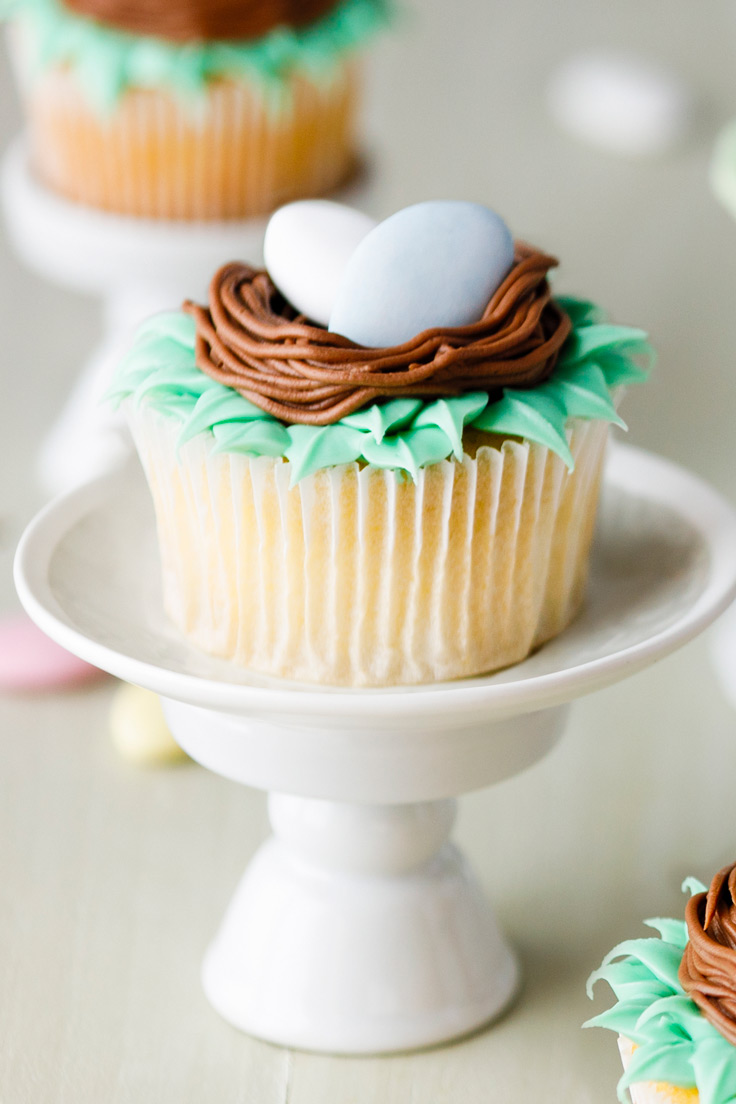 Amoretti Pistachio Cupcakes Recipe with Dragee Nests on white pedestal
