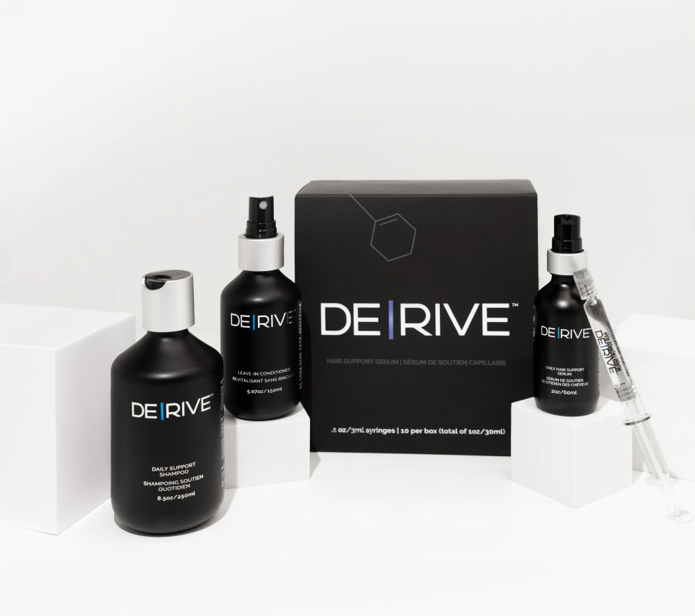 DE|RIVE Hair Wellness System product collection including serum, shampoo, and conditioner
