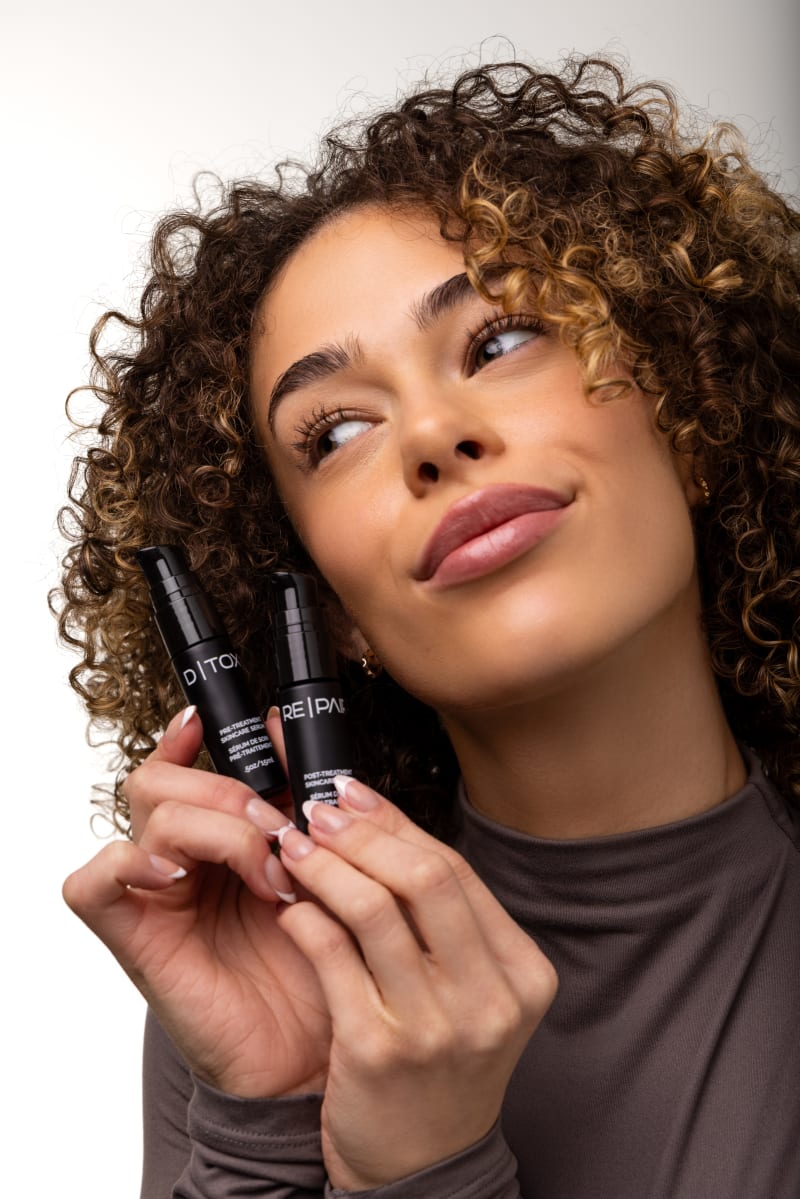 Beautiful woman holding D|TOX and RE|PAIR bottles