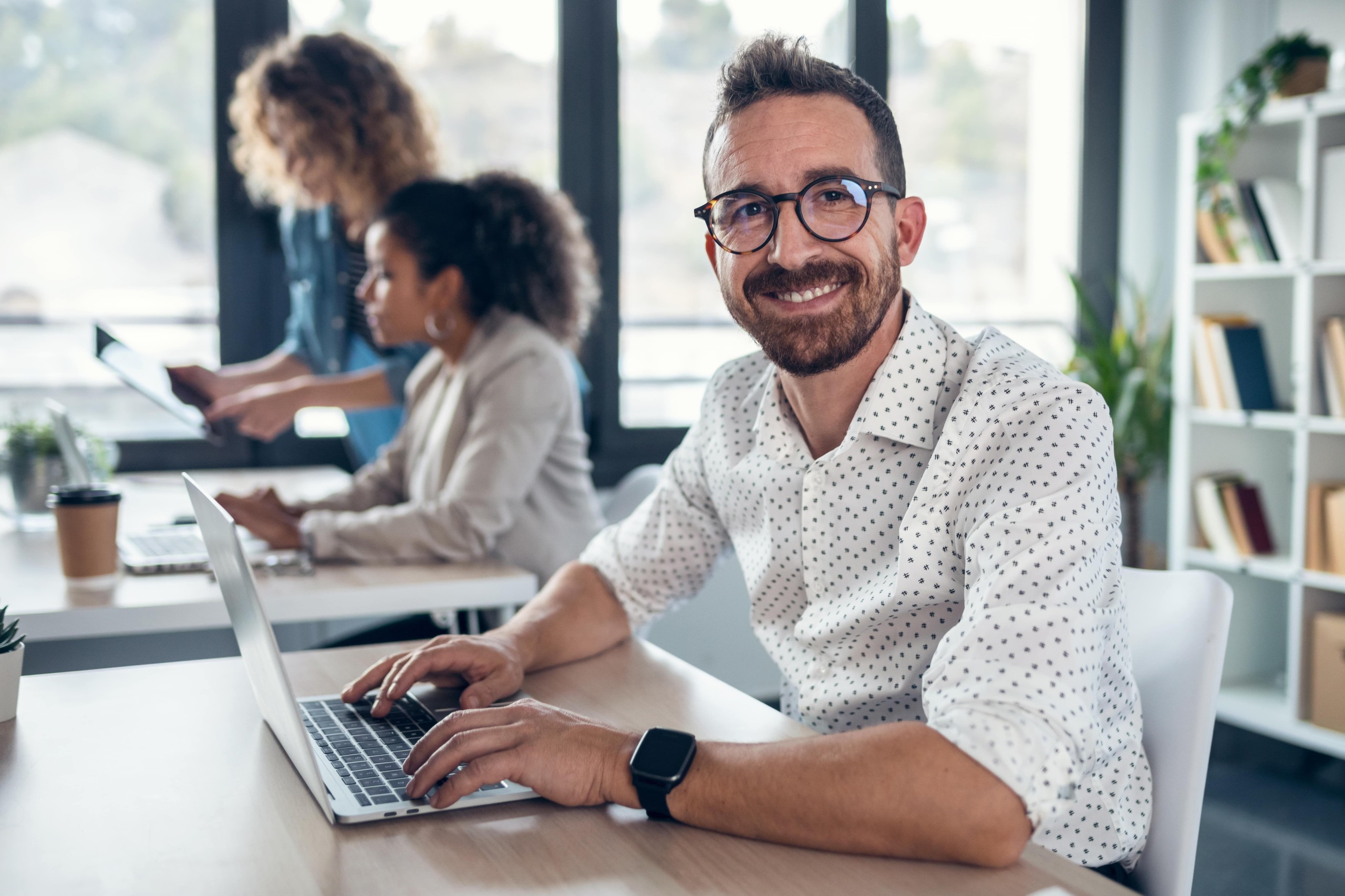 ANAGO_Corporate_Man_behind_desk_laptop_smiling_2115521348_300dpi-min.jpg