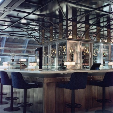 A film shot inside St. Pancras station, of the main serving area of the Champagne Bar. Shot on Portra 400NC, the muted colours of the film complement the metallic structures to add a sheen / © Michael Elliott