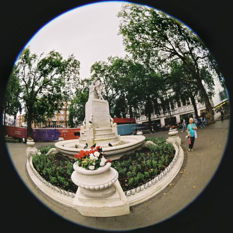 The statue of William Shakespeare is the centrepiece of Leicester Square Gardens, cloudy morning light.