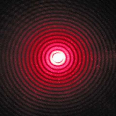 A diffraction pattern of a laser beam passing through a small circular aperture — Wikimedia Commons.