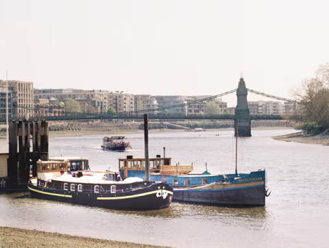 View of the Thames River and the Hammersmith Bridge.  This stretch of the river has a number of long-term mooring sites for house-boats.