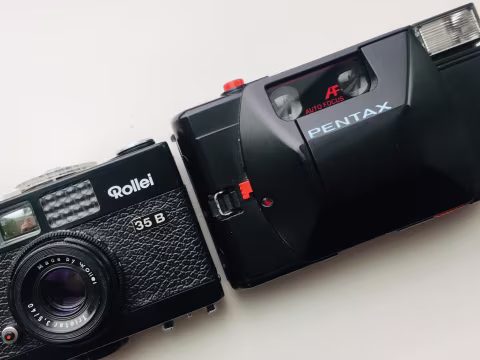 Pentax PC35AF is another premium compact camera. Having been released about twenty years after Rollei, it manages to pack auto-focus and auto-exposure along with flash into an only marginally larger body. It’s also cheaper, though its build quality is not as solid, and it doesn’t provide that sweet manual, fully-mechanical action Rollei has.