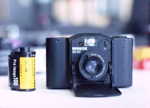 Minox 35 GT, next to a film canister.