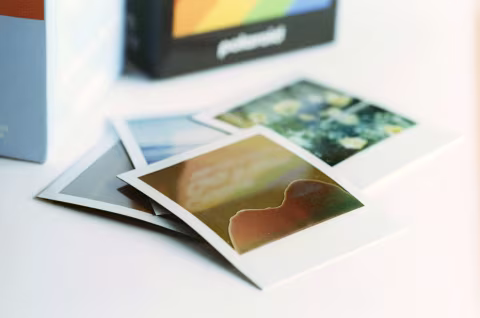 A small pile of Polaroid Go film with a damaged frame on top.
