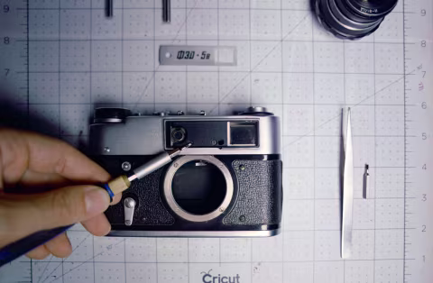 The two screws for rangefinder adjustments on FED 5B are underneath the name plate.