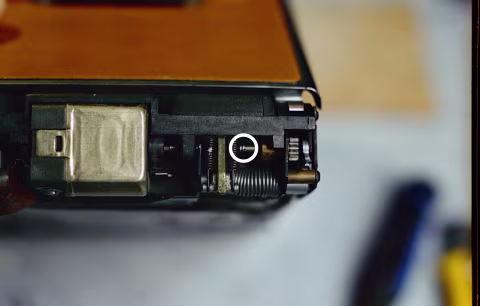 This is the side of the camera where you’ll normally see a film counter display. With the top of the camera facing up in this photo, the circled area is where you’ll find a translucent plastic component. This is a photo of a repaired camera, so you can’t see the translucent component, but the circled area is where you should look for it on your camera.
