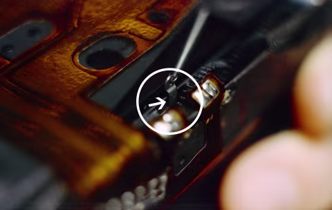 The lubricant should be applied between the arm and the rail it slides on top of.
