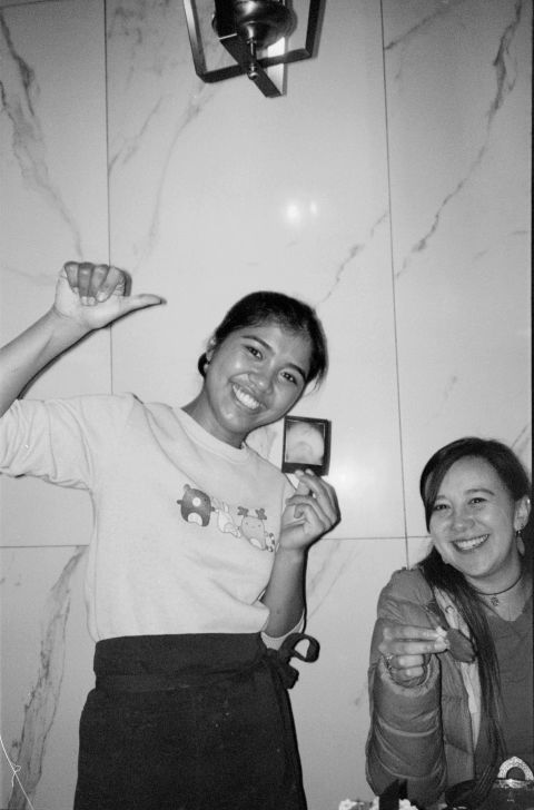 A friendly waiter holding up her portrait, shot with Gingerbread 1 instant film camera. The camera travelled around town for a few days before becoming food. It was never refrigerated.