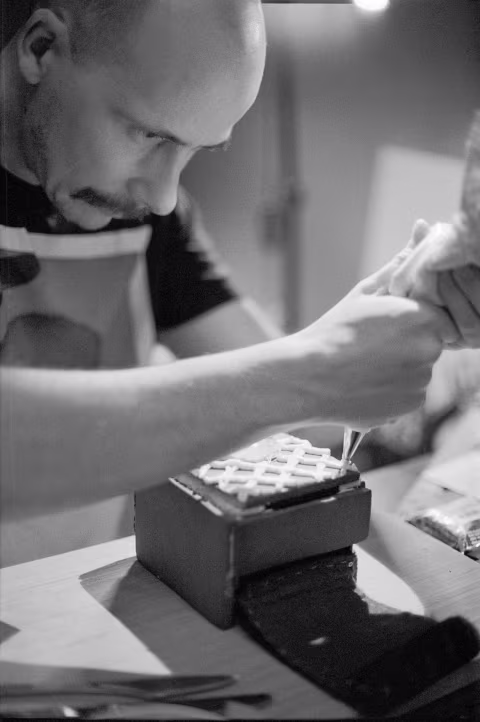 Decorating the front plate with a pre-planned crisscross pattern. Gingerbread 2 has deliberately less icing near its bottom half and the sides (places it’s handled the most).