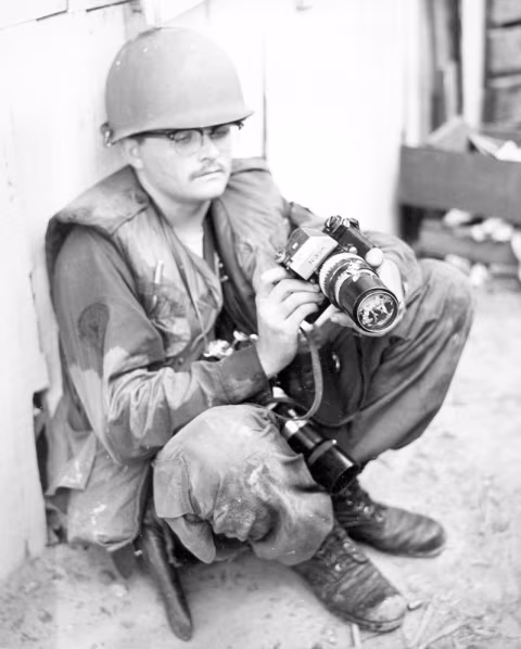 7 May 1968 Tan Son Nhut — SP5 C.K. Pollard Jr., photographer for the 69th Sig. Bn. (A), holds a camera that was hit by an enemy bullet. The Vietnam Center and Archive, Texas Tech University. flickr.com/photos/97930879@N02/9434735530.