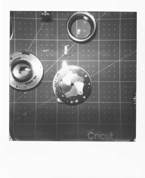 Leaf shutter assembly of a Vitessa L camera (bottom-right-most piece).