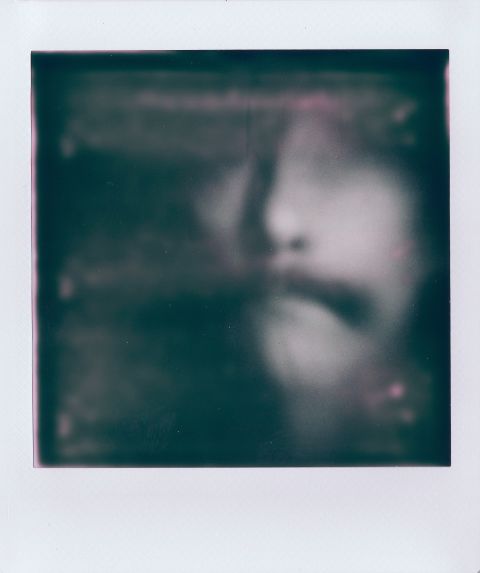 A portrait of me looking like Moriarti on Instax Square Monochrome with Gingerbread 1.