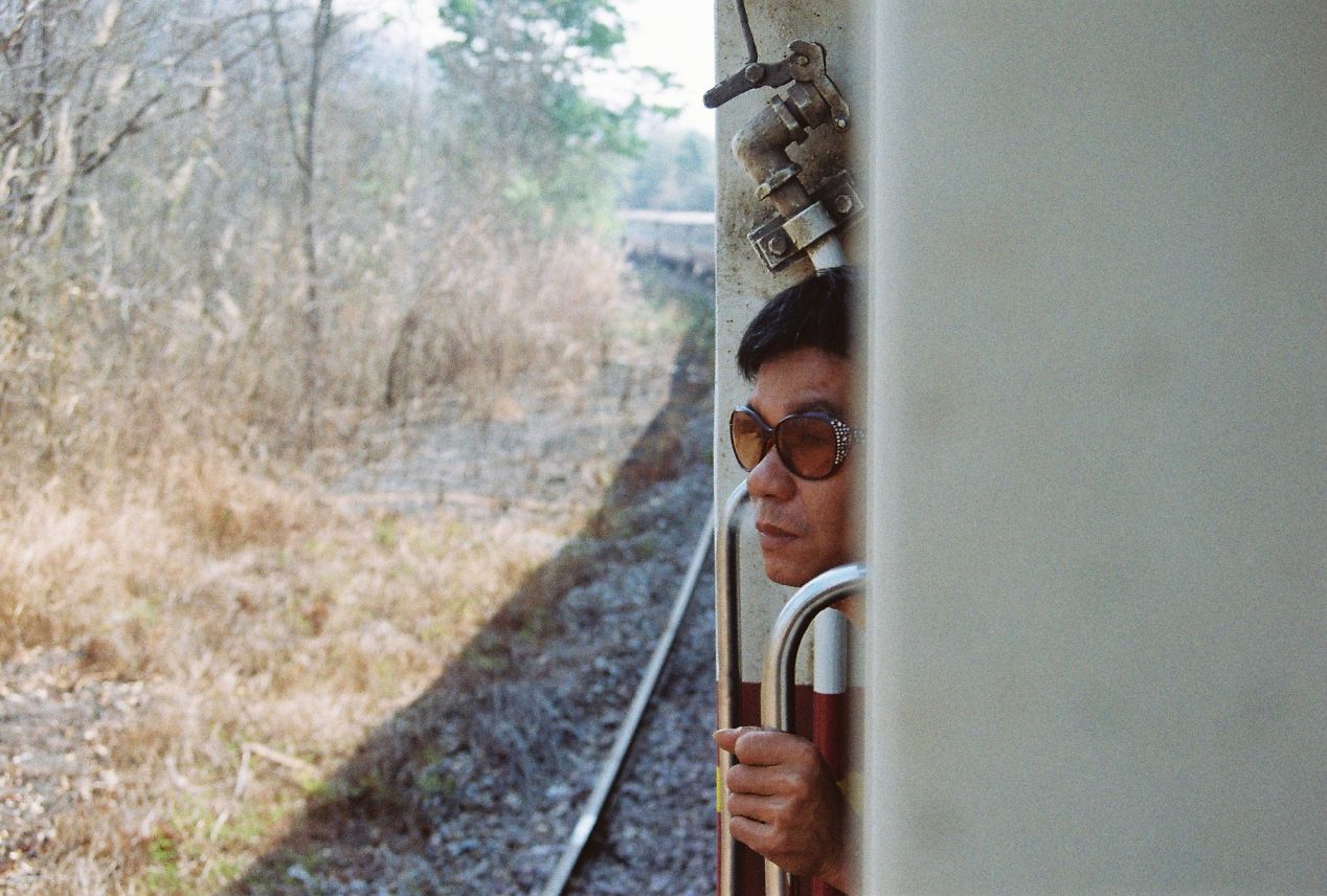 A gentlemen wearing strange shades looking out from the train window as we snail towards Bangkok. Yashica FX3 Super 2000, Color Plus 200.