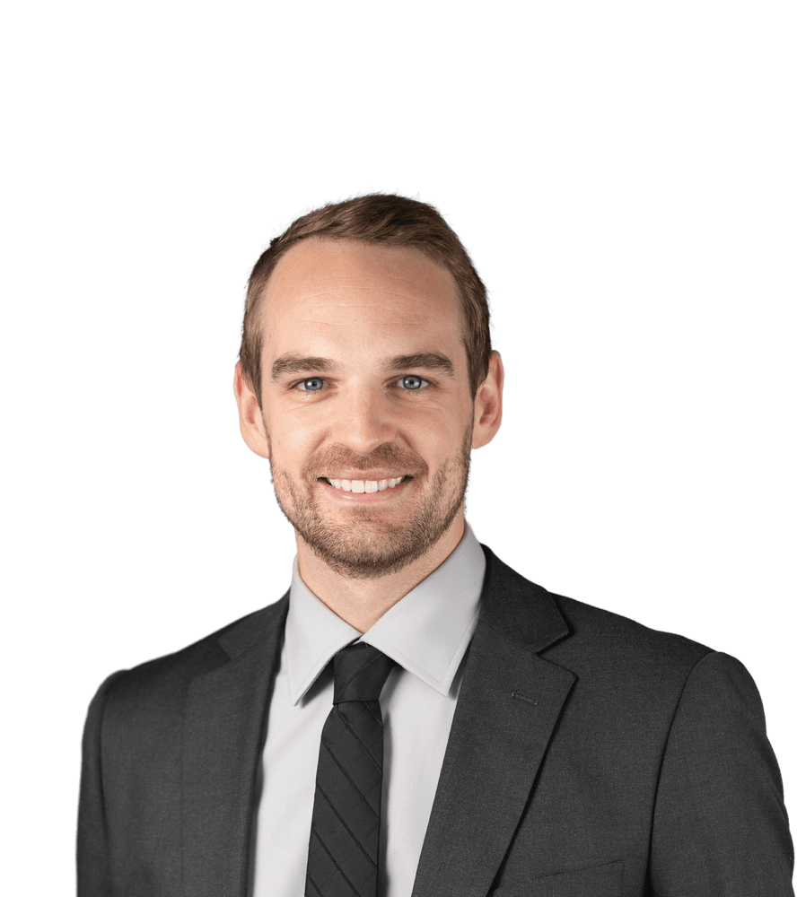 A man in a suit and tie, smiling cheerfully, conveying a professional demeanor.